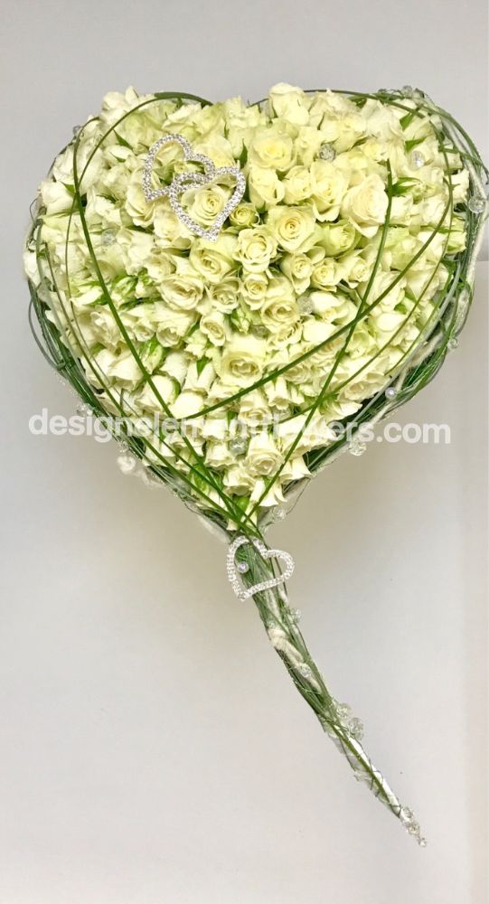 Brides Heart Bouquet created with Bear Grass and White Spray Rose , White Roses finished with a Diamante Heart